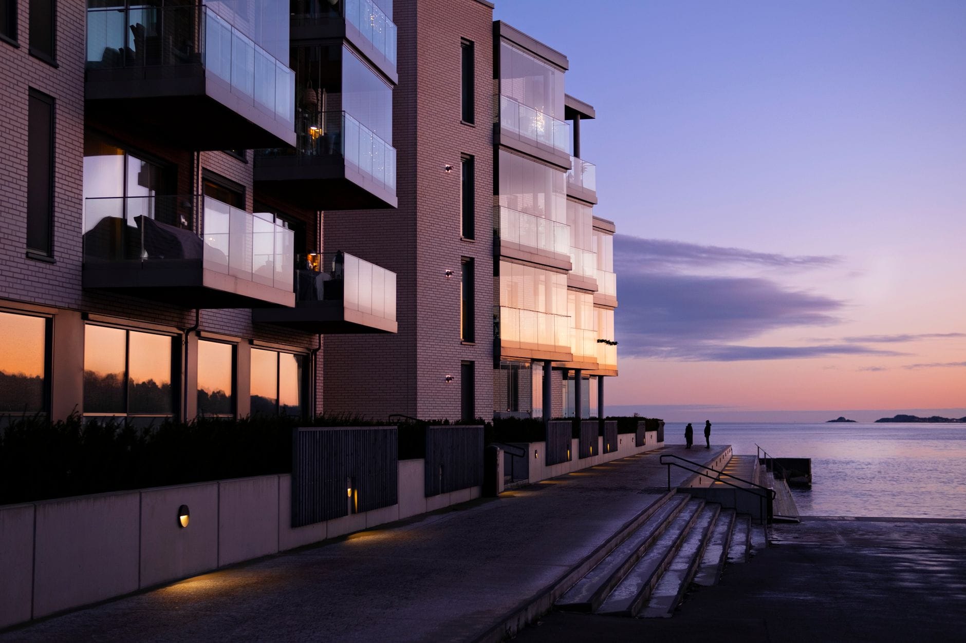 Nowoczesny apartamentowiec nad morzem o zachodzie słońca