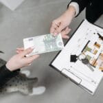 Klucze, banknot euro i plan mieszkania przy zakupie nieruchomości
